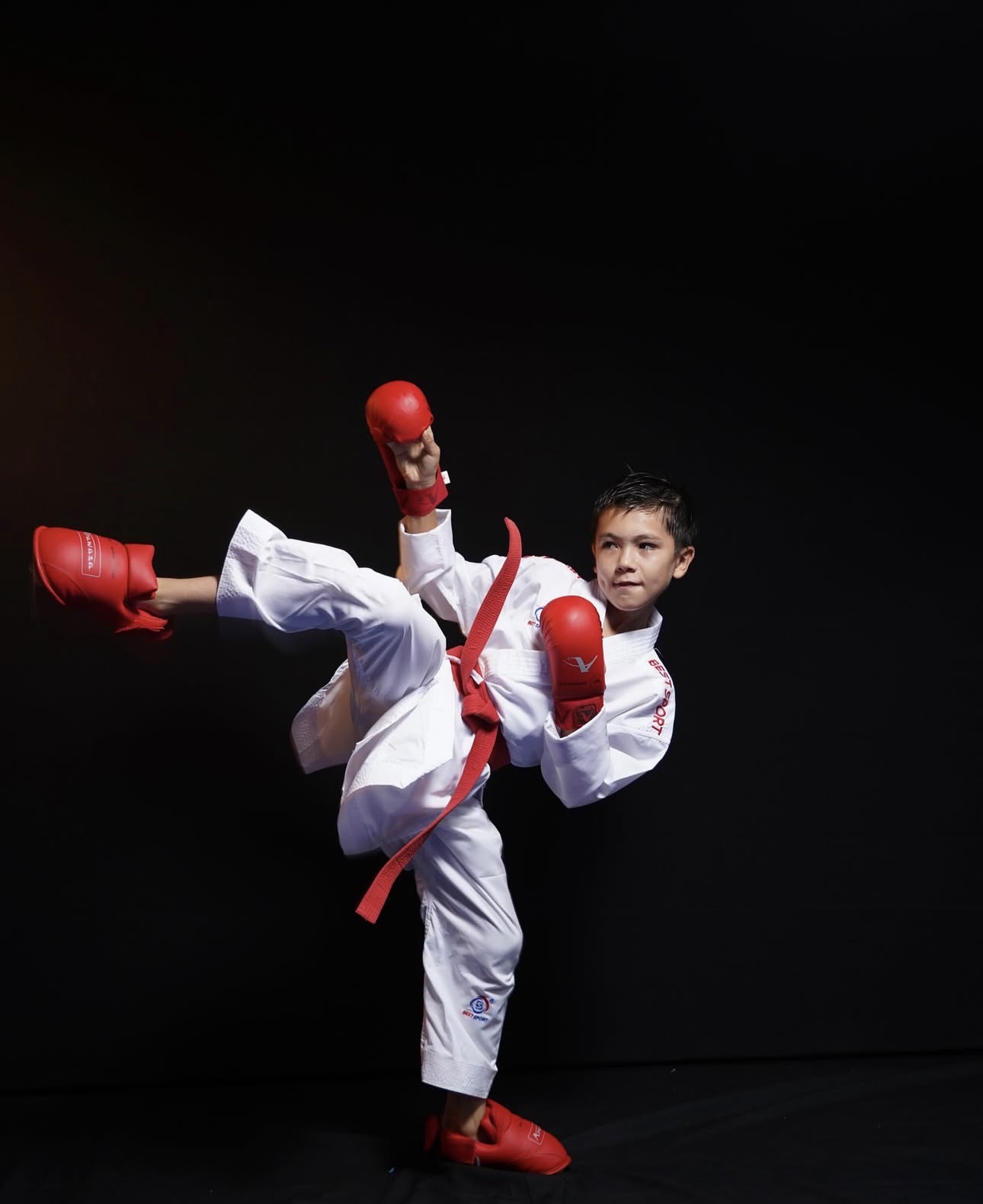 Αθλητής karate με προστατευτικά Best Sport σε υψηλή κλωτσιά