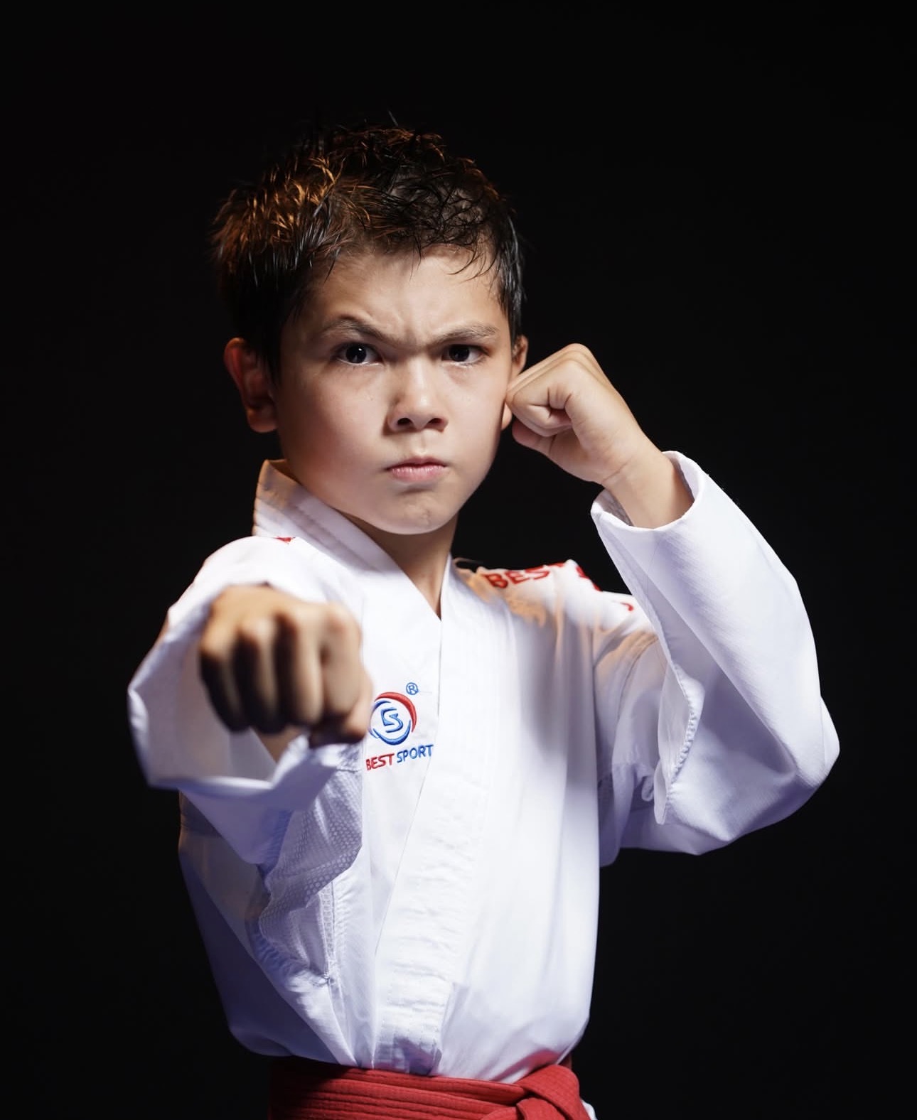 Νεαρός αθλητής karate με στολή Best Sport σε στάση γροθιάς