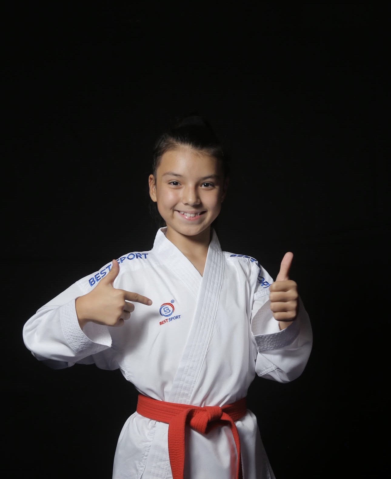 Αθλήτρια karate δείχνει το λογότυπο Best Sport